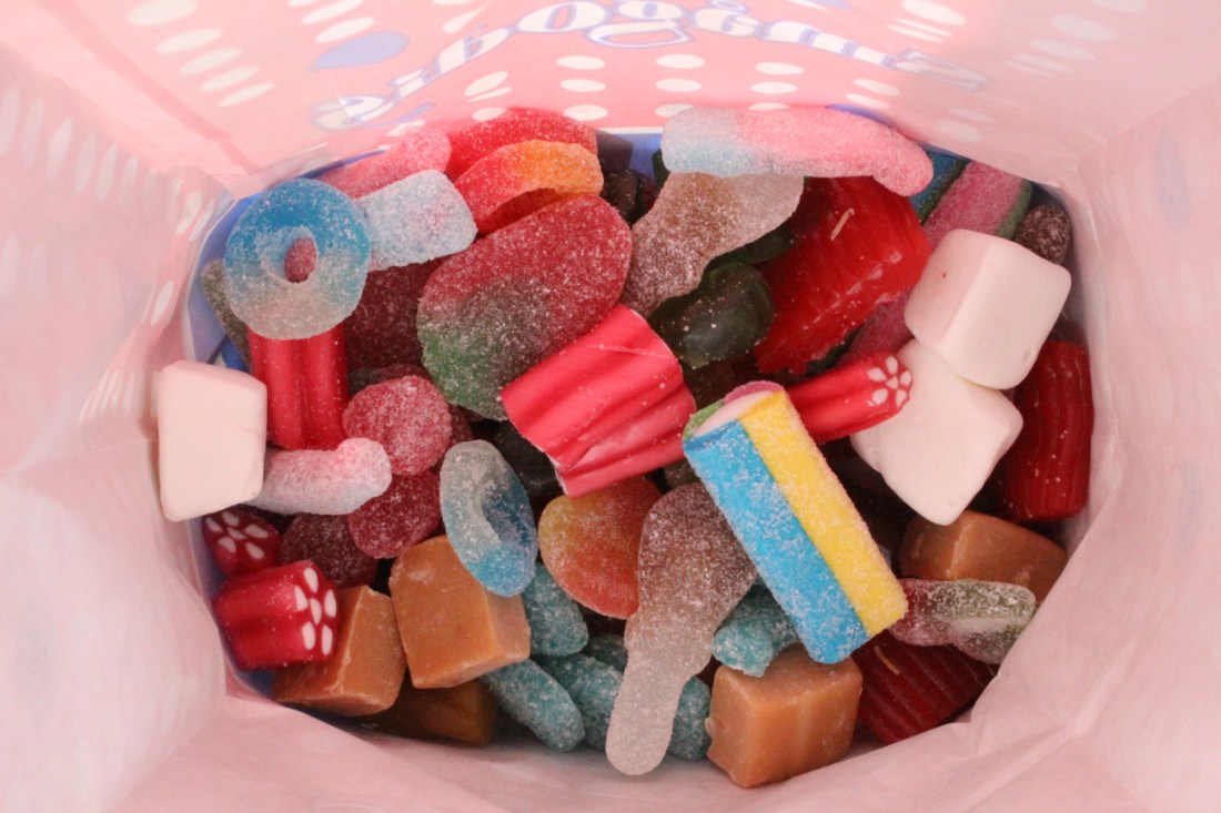 Volle Tüte mit Süßigkeiten, Innenansicht. Die Tüte macht einen rosa Schimmer.