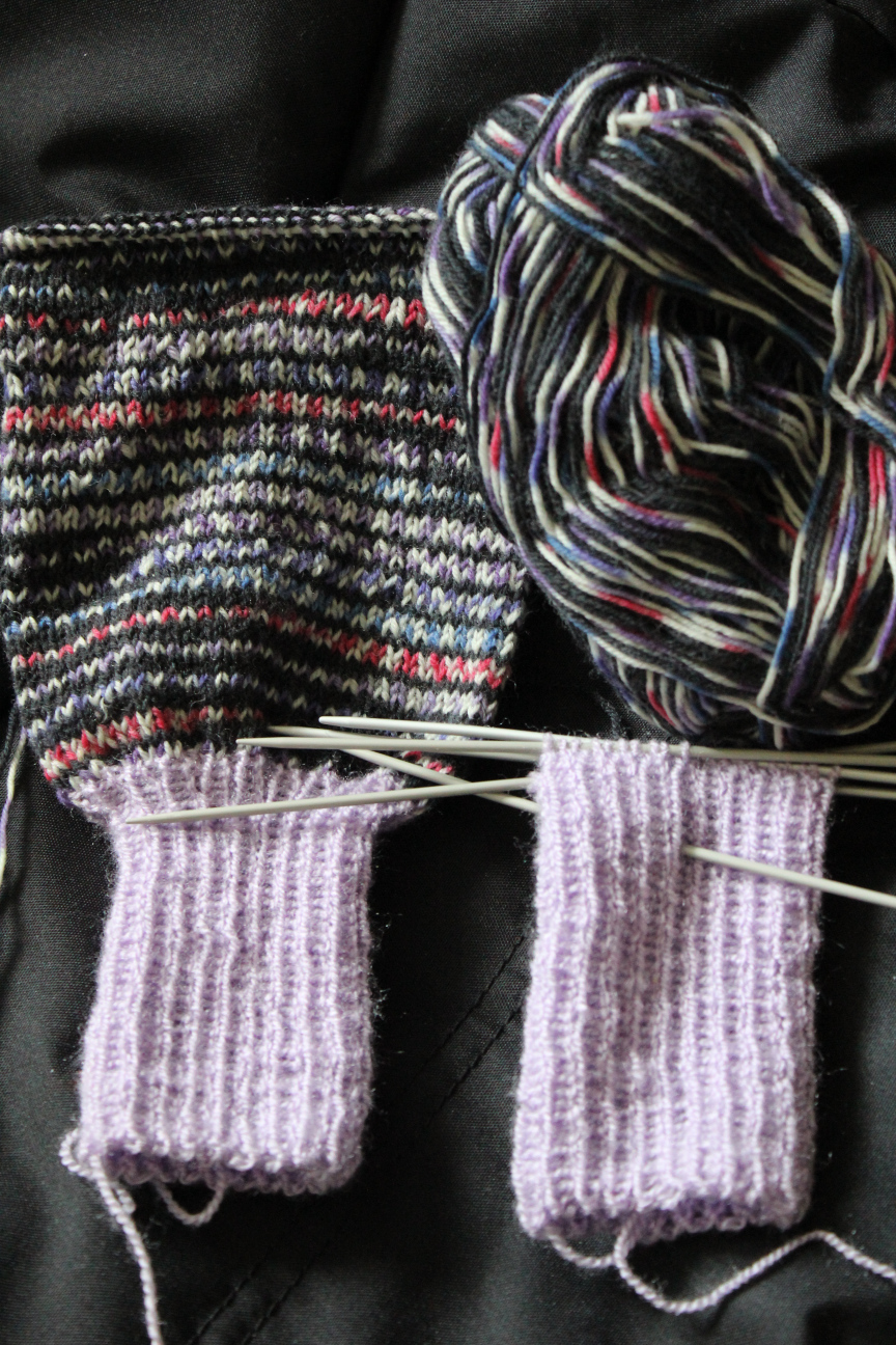 Beine einer Wollhose, still in progress. Hellila Fußteile, dunkellila Beinteile aus Sockenwolle.