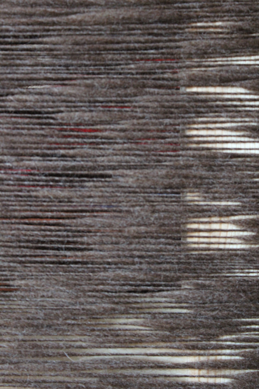 Um Stuhllehne gewickelte dunkelbraune Wolle