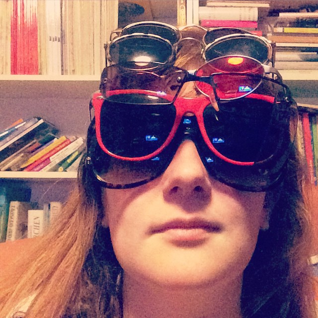 Selfie; ich trage sechs verschiedene Sonnenbrillen übereinander und gucke ins Lampenlicht.