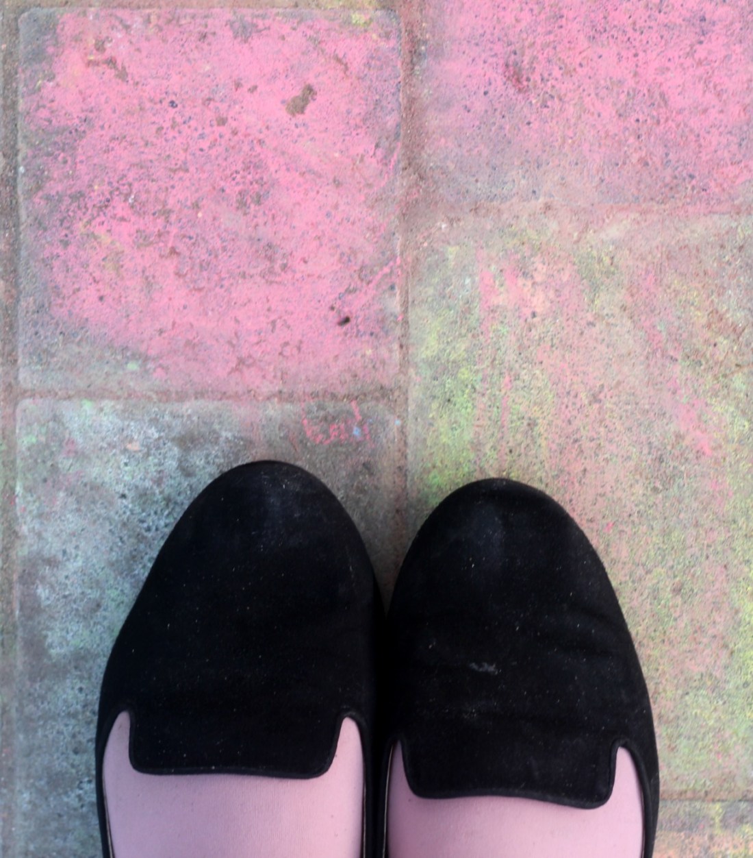 Die Spitze meiner Schuhe auf mit pinker Kreide bemaltem Boden.